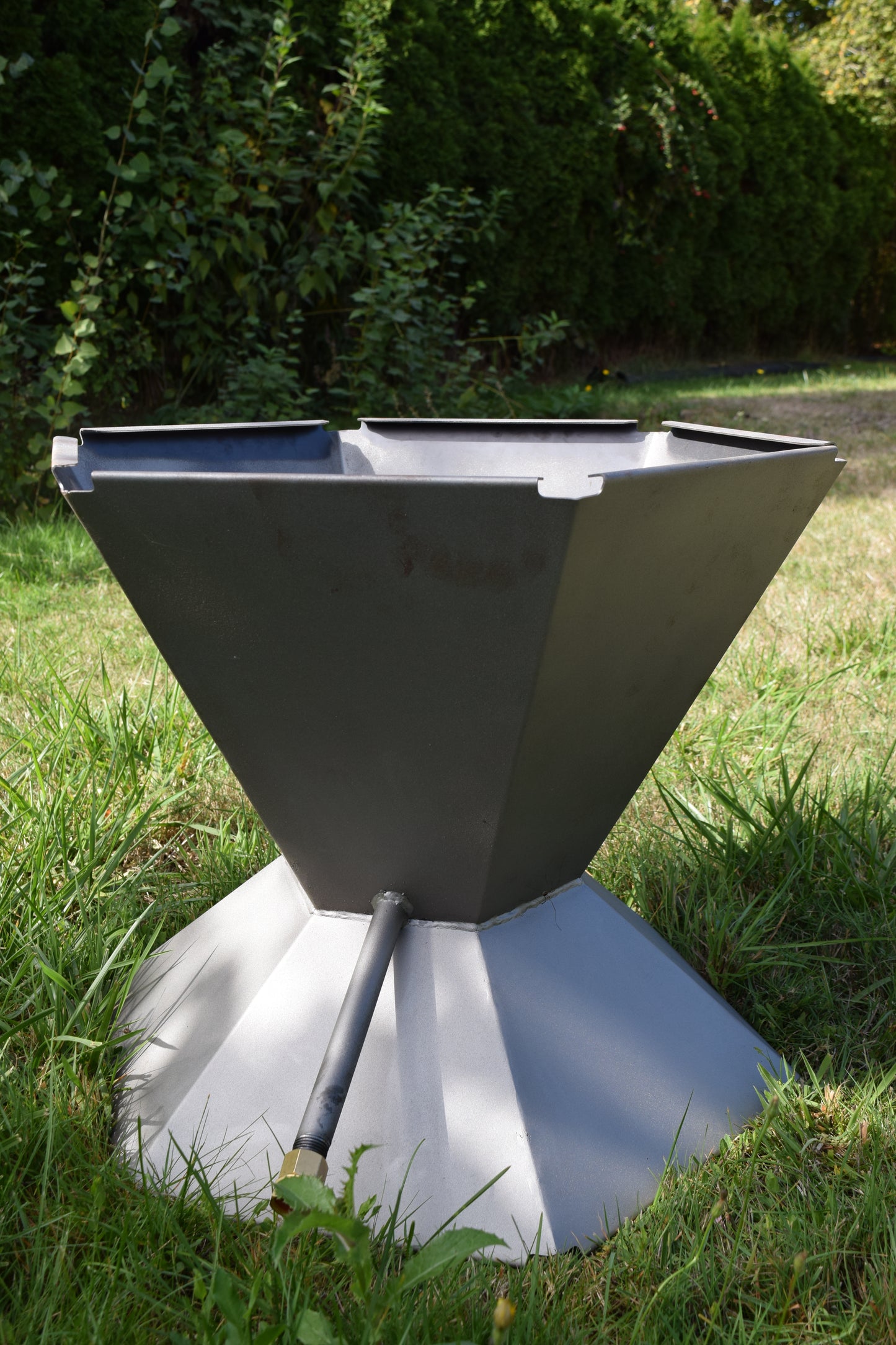 Back view of he Biochar Fire Pit showing the hose attachment for bottom up quenching.