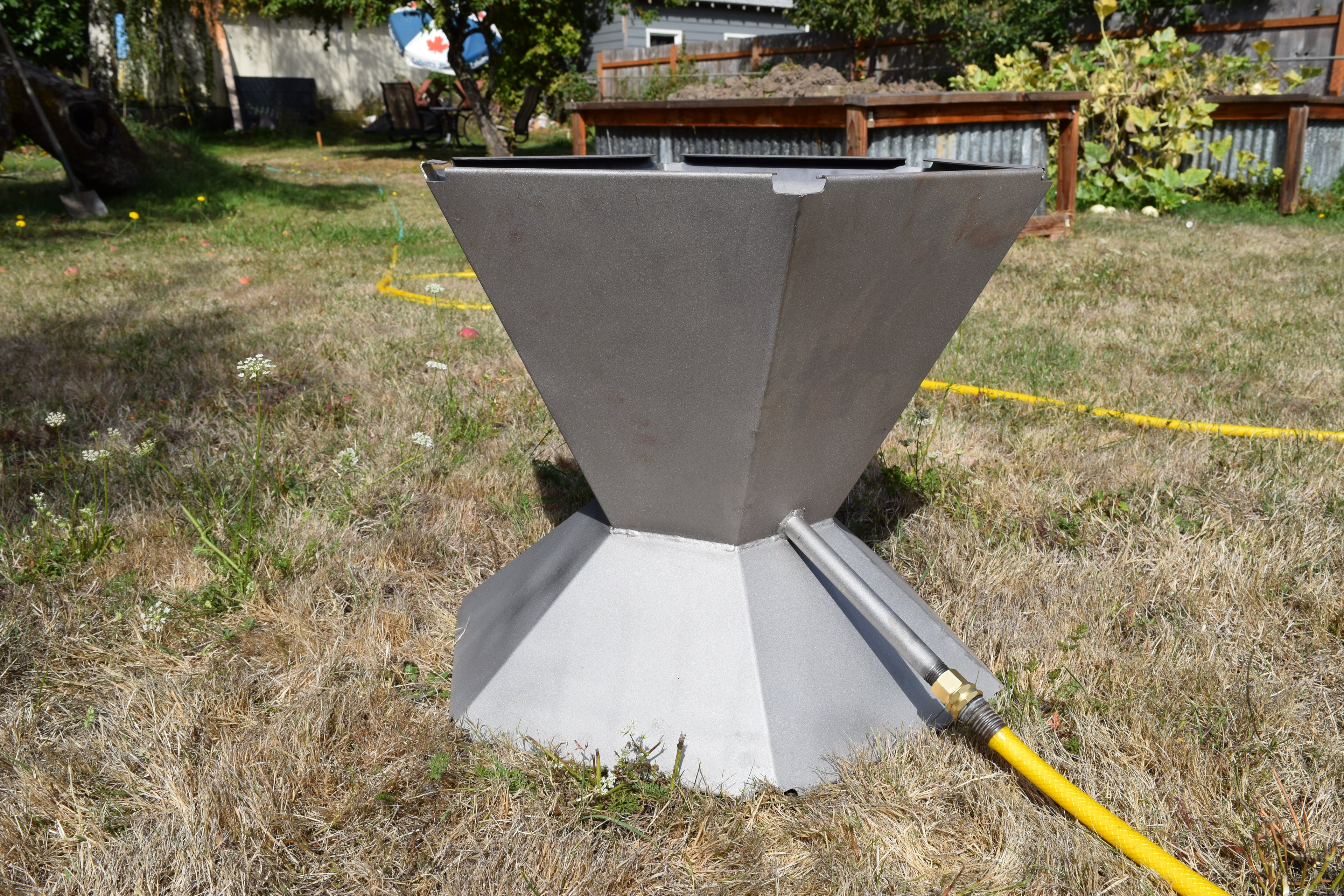 Biochar fire pit shown from hose attachment side.