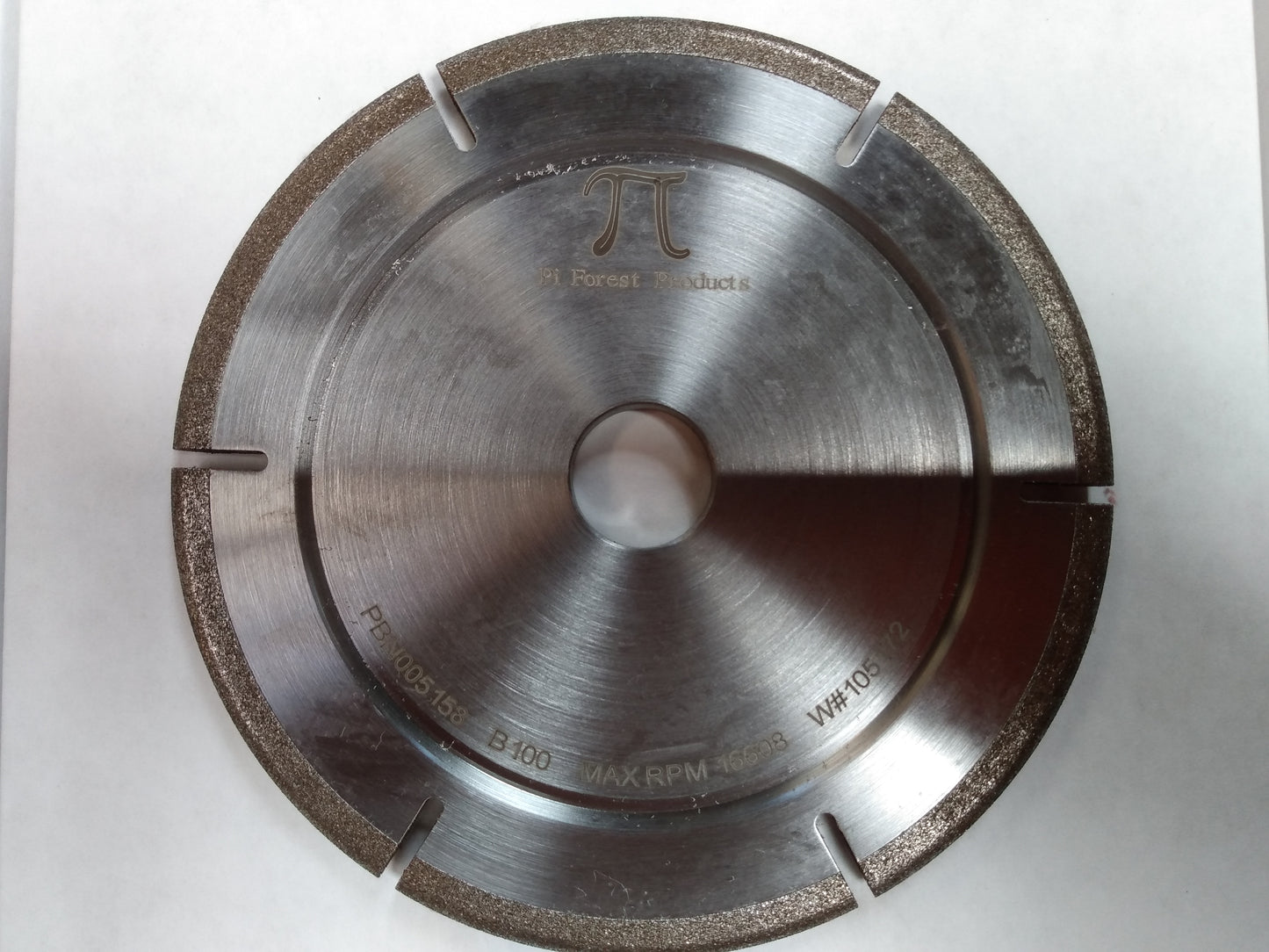 Top view of a Pi Fabricators brand 100 grit CBN grinding wheel including cutouts.