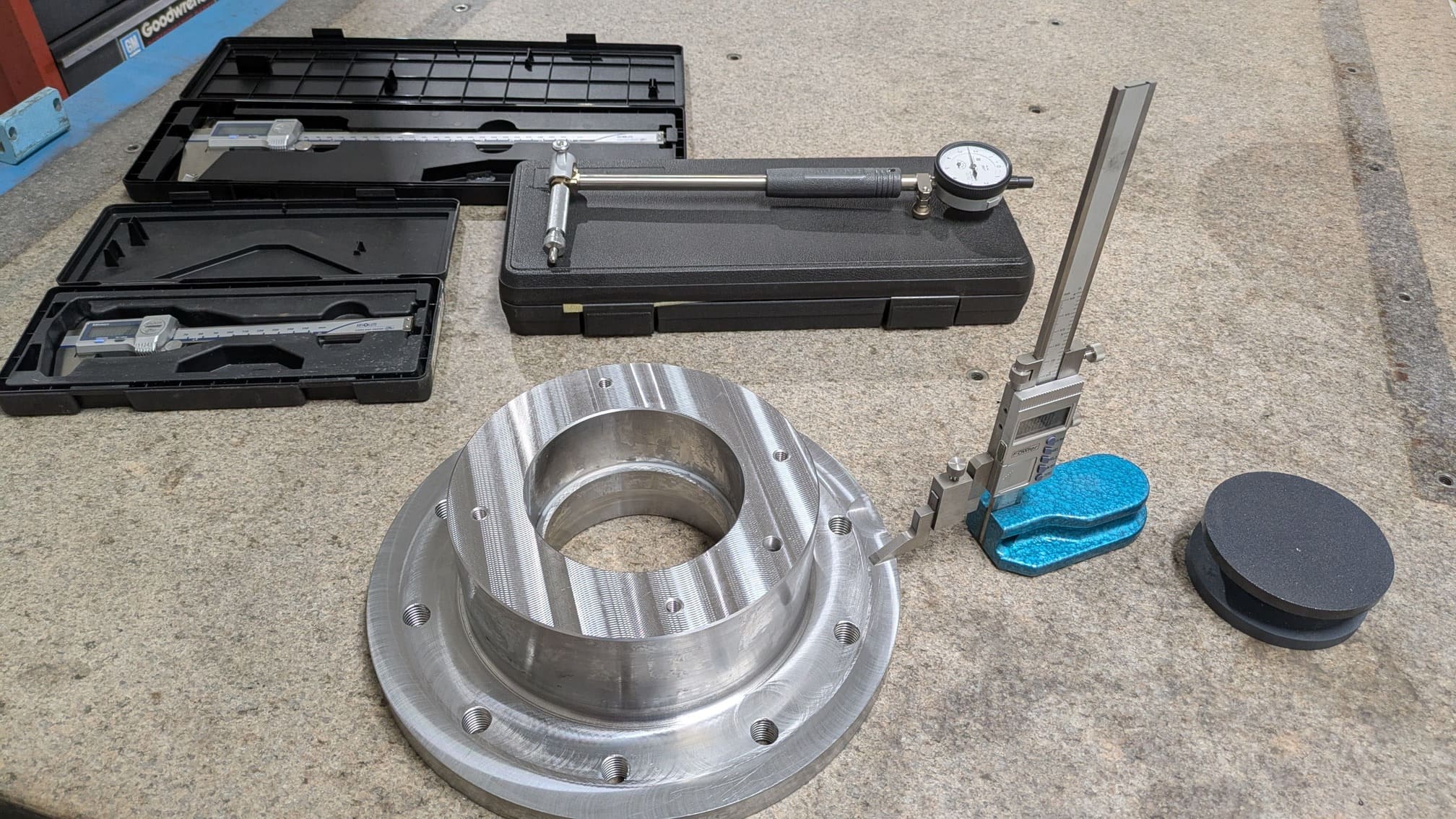 Inspection equipment including a height gauge, calipers and bore gauge on a granite slab. 