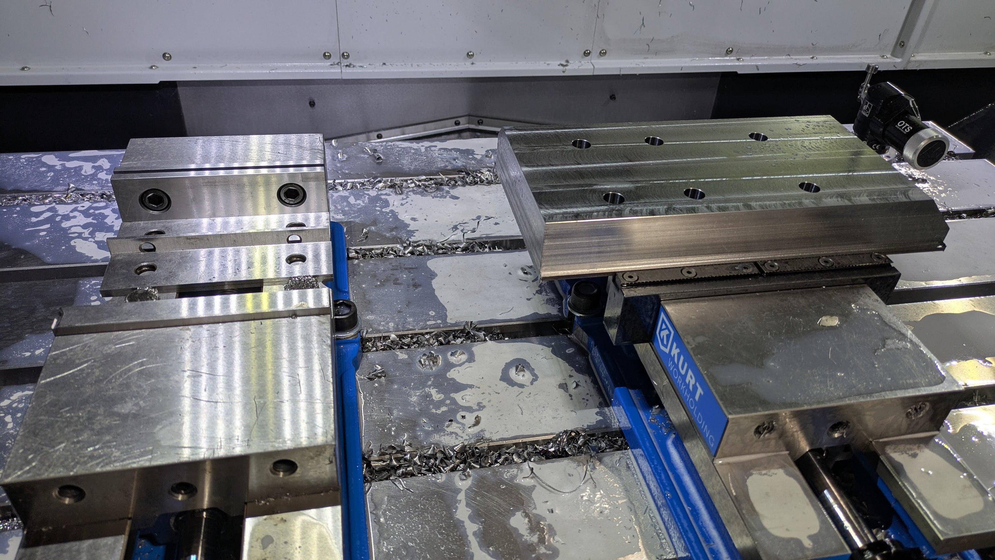 Steel plate partly machined held in vise. 