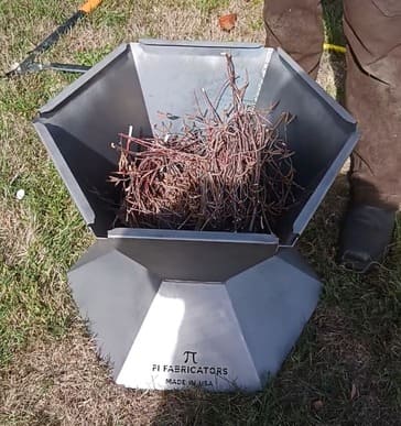 Pi Fabricators biochar kiln, Made in USA, pictured filled with small twigs (tinder) and ready to be lit for operation.