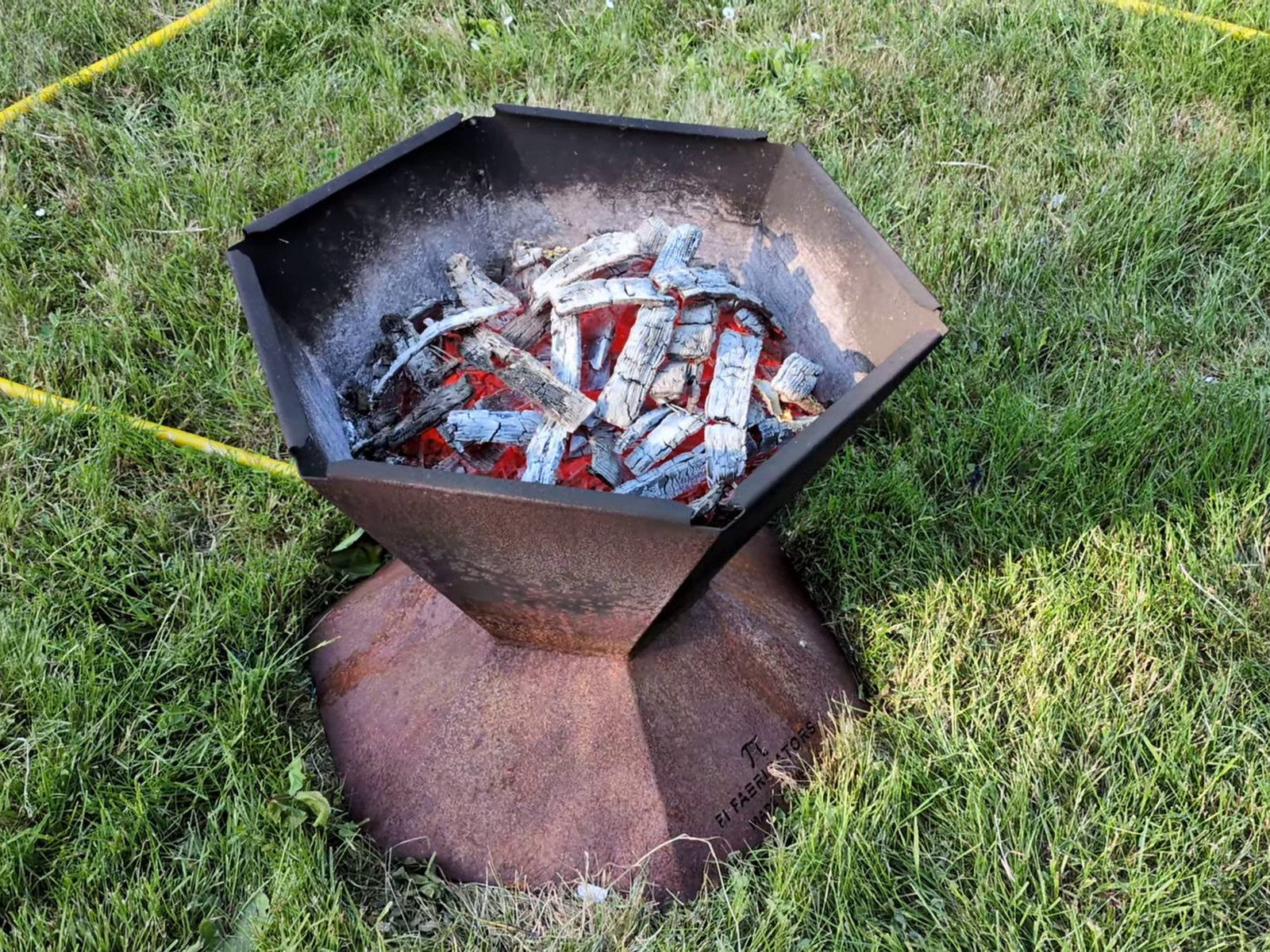 Glowing red charcoal with no flames left in the Biochar-Making Fire Pit, ready to quench