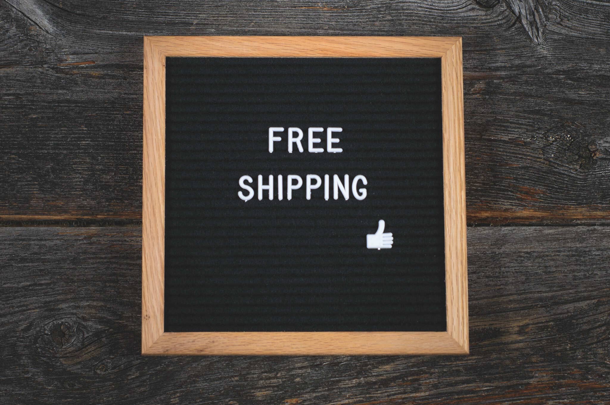 Letter board with 'FREE SHIPPING' text on a wooden background