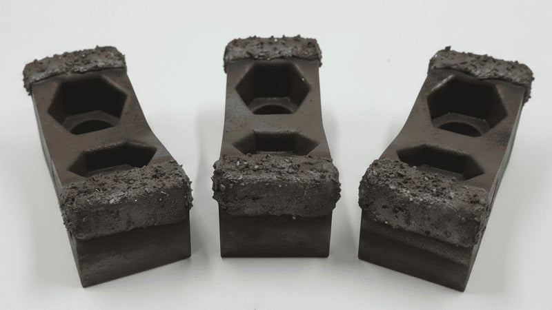 Three hammer hog hammers with a rough, MIG tungsten carbide embedded hardfacing applied to the striking edges for extreme wear resistance in wood grinding.